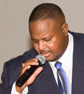 Bishop anderson singing into a mic with eyes closed